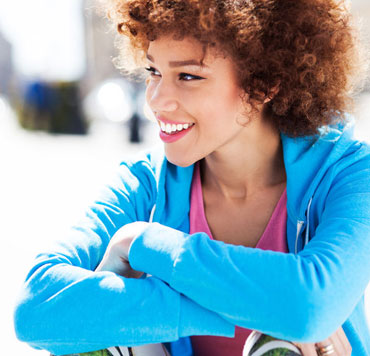 Photo d'une jeune femme souriante pour illustrer que dans le christianisme, il n'y a pas le fardeau de gagner l'acceptation de Dieu.'s acceptance.