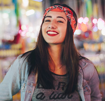 Foto di una giovane donna sorridente per illustrare che nel cristianesimo non c'è l'onere di guadagnare l'accettazione di Dio.'s acceptance.