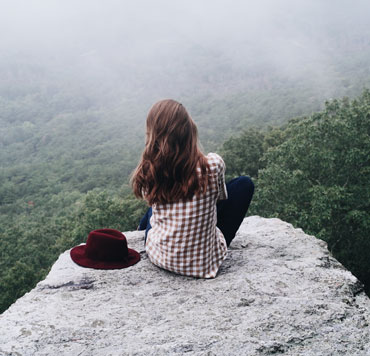 Photo of a young woman looking out into the light-filled distance, to show that God is the light for guidance in all things.