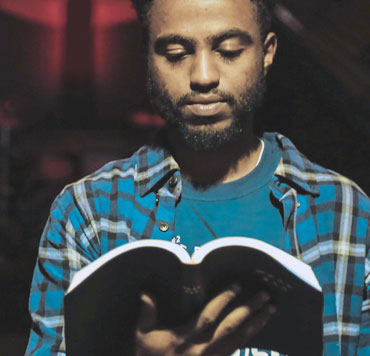 Photo of a man reading the Bible to illustrate that God has revealed his existence to us in the Bible.